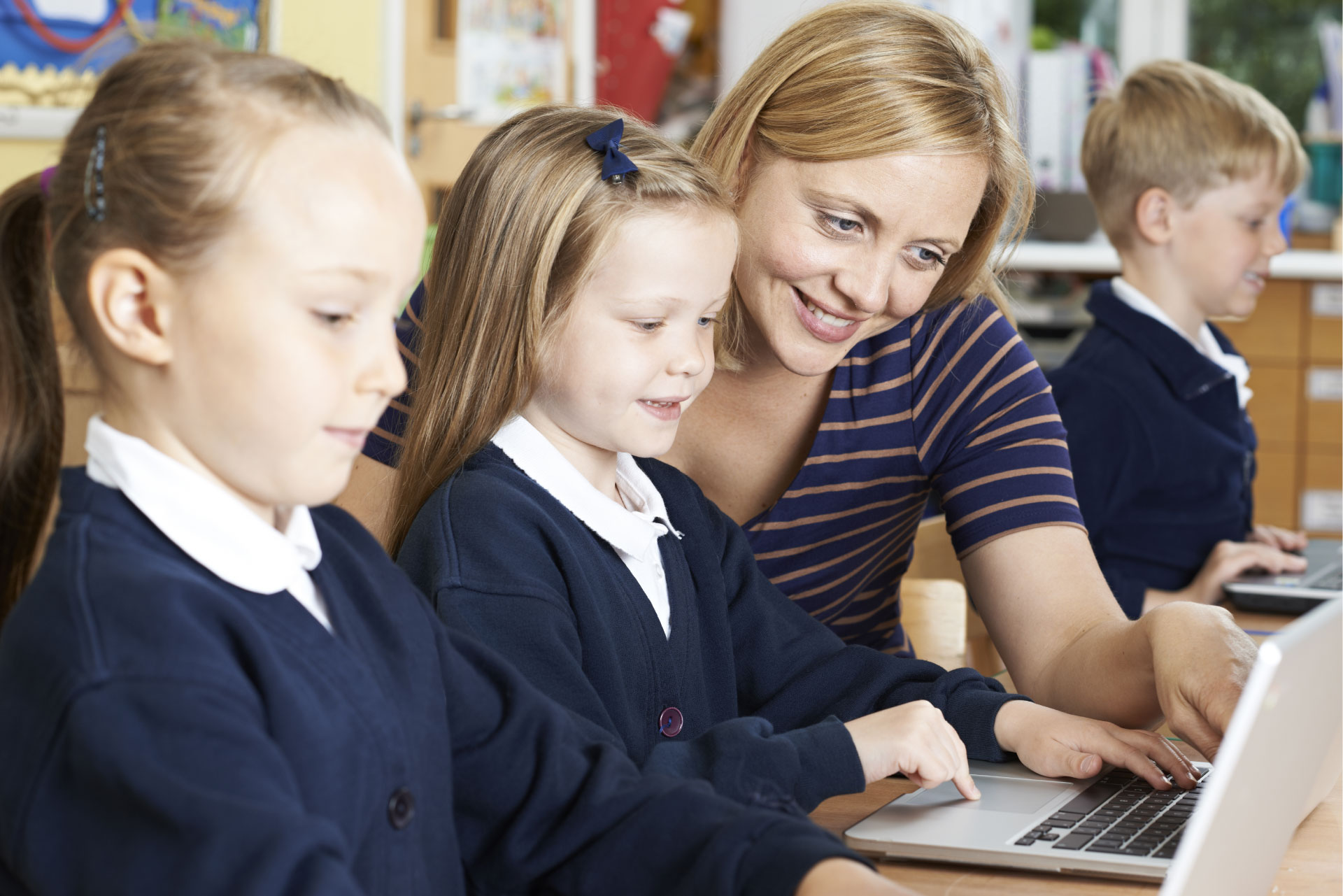 teacher helping student on laptop